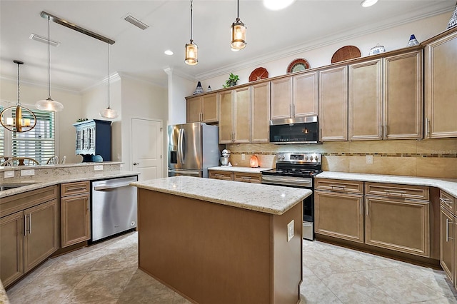 kitchen with appliances with stainless steel finishes, decorative backsplash, light stone countertops, a kitchen island, and pendant lighting