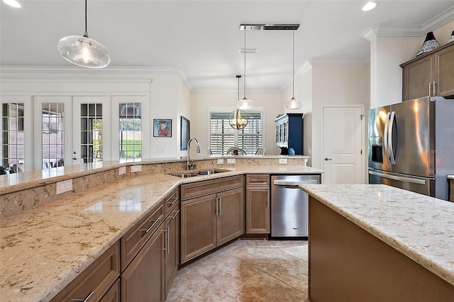 kitchen with decorative light fixtures, sink, stainless steel appliances, and french doors