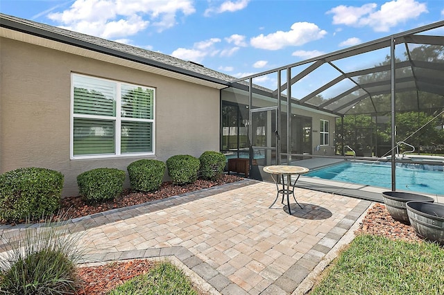 view of swimming pool with glass enclosure and a patio area