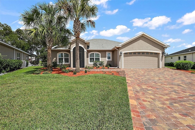 view of front of house with a garage, a front yard, and central AC