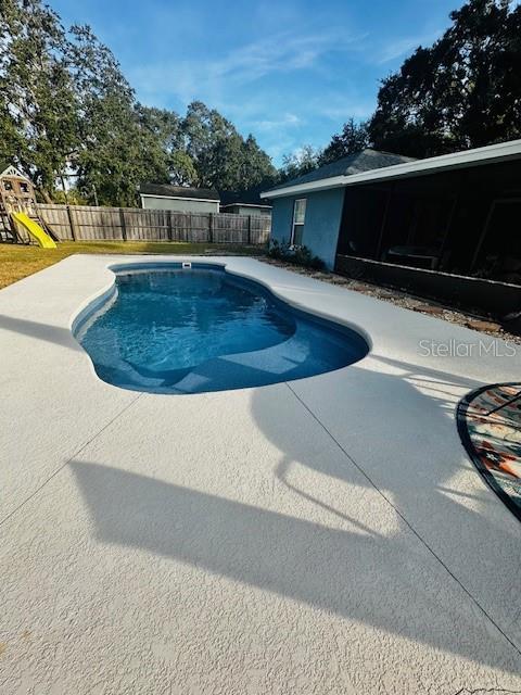 view of pool featuring a patio and a playground