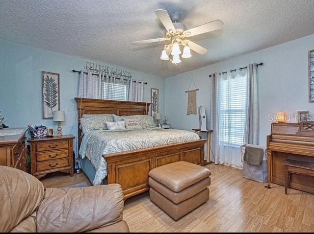 bedroom featuring ceiling fan, a textured ceiling, and light hardwood / wood-style flooring