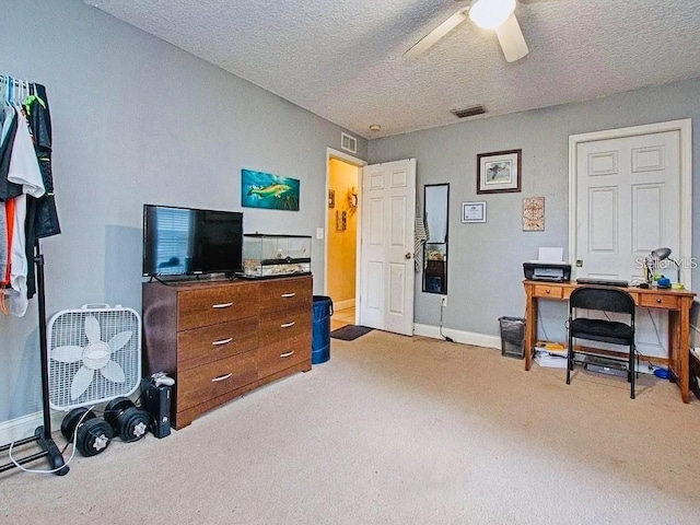 carpeted office with ceiling fan and a textured ceiling