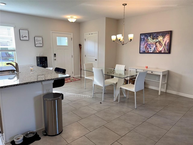 dining room with light tile patterned flooring, a notable chandelier, and baseboards