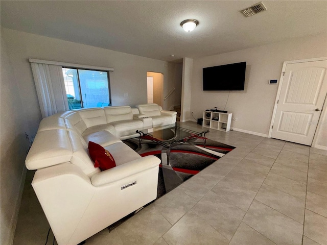 living room featuring light tile patterned flooring and a textured ceiling