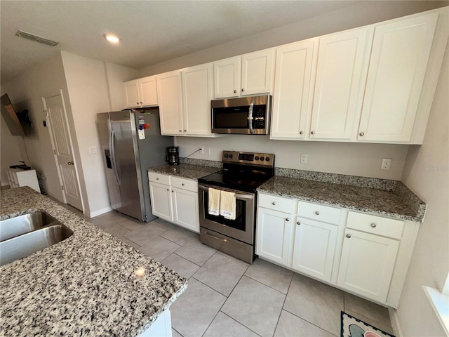 kitchen featuring stone counters, white cabinetry, visible vents, and stainless steel appliances