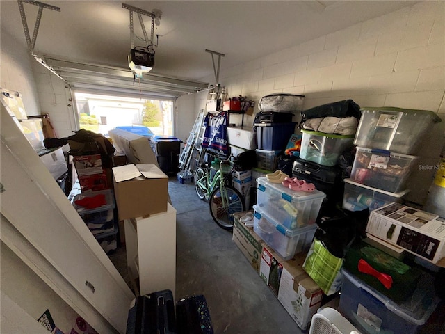 garage with concrete block wall and a garage door opener