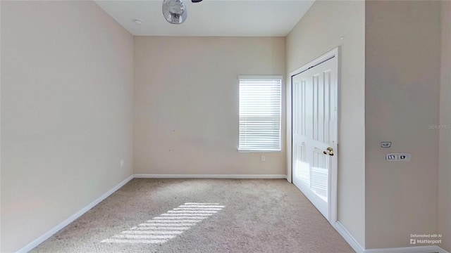 unfurnished room featuring light carpet