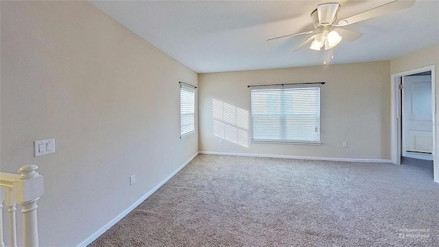 carpeted spare room featuring ceiling fan