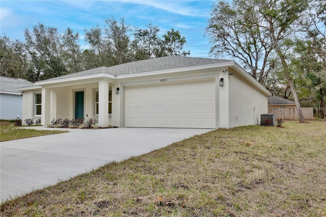 ranch-style home featuring a front lawn, a garage, and central AC