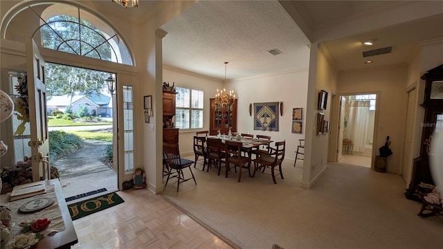 foyer with light parquet floors, a chandelier, and a textured ceiling