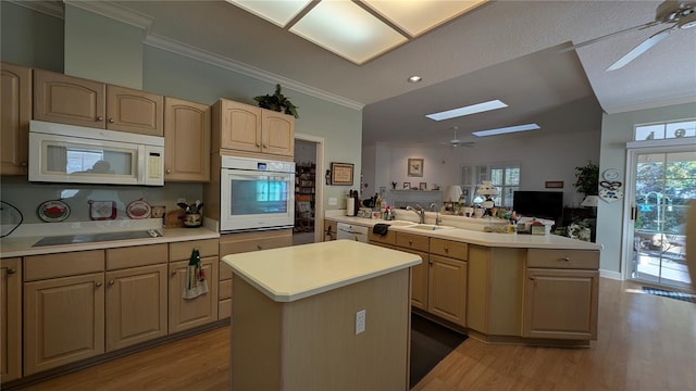 kitchen featuring ceiling fan, a center island, and white appliances