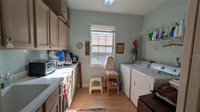 washroom featuring sink, light hardwood / wood-style floors, and washer and dryer