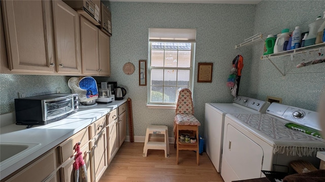 laundry area featuring cabinets, light hardwood / wood-style flooring, and washer and dryer