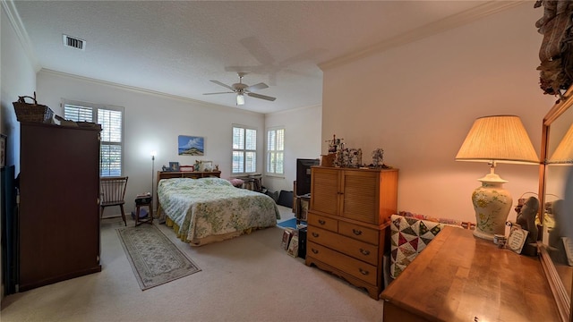 bedroom with ceiling fan, crown molding, carpet floors, and a textured ceiling