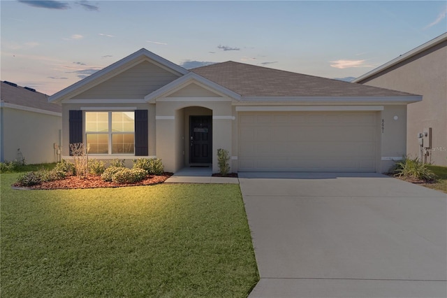 ranch-style home featuring a garage and a yard