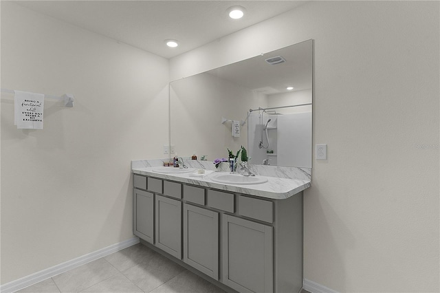 bathroom with tile patterned floors, vanity, and a shower