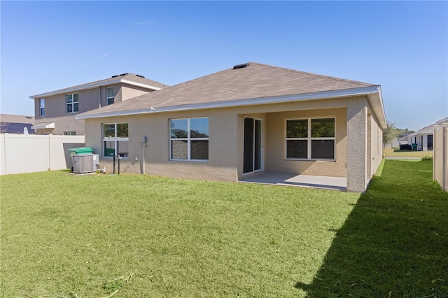 rear view of property with a yard, a patio area, and central air condition unit