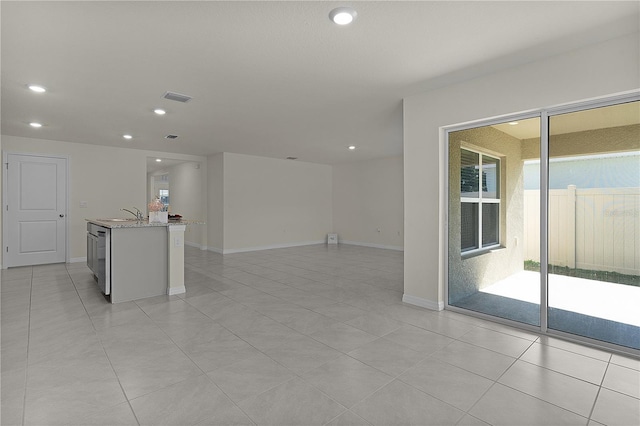 empty room featuring sink and light tile patterned floors