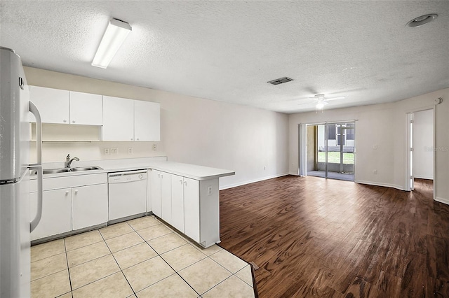 kitchen with white appliances, white cabinetry, sink, kitchen peninsula, and ceiling fan