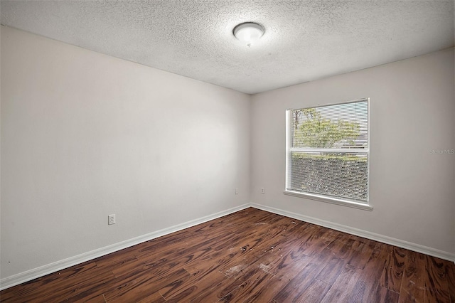 unfurnished room with a textured ceiling and dark hardwood / wood-style flooring