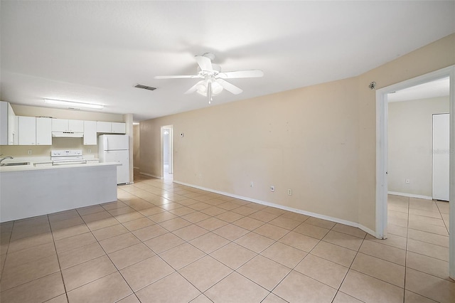 unfurnished living room featuring ceiling fan, sink, and light tile patterned flooring