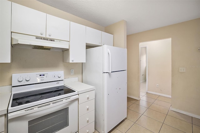 kitchen with light tile patterned floors, white cabinets, and white appliances