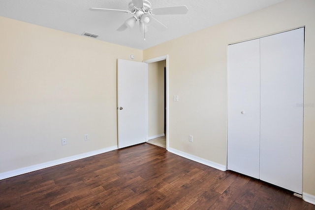 unfurnished bedroom featuring ceiling fan, a closet, and dark hardwood / wood-style floors