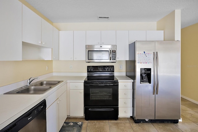 kitchen featuring light tile patterned floors, white cabinetry, appliances with stainless steel finishes, a textured ceiling, and sink