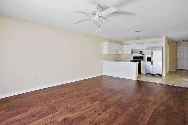 unfurnished living room featuring ceiling fan and light hardwood / wood-style flooring