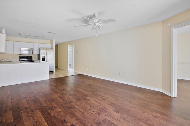 unfurnished living room with ceiling fan, sink, and light hardwood / wood-style flooring