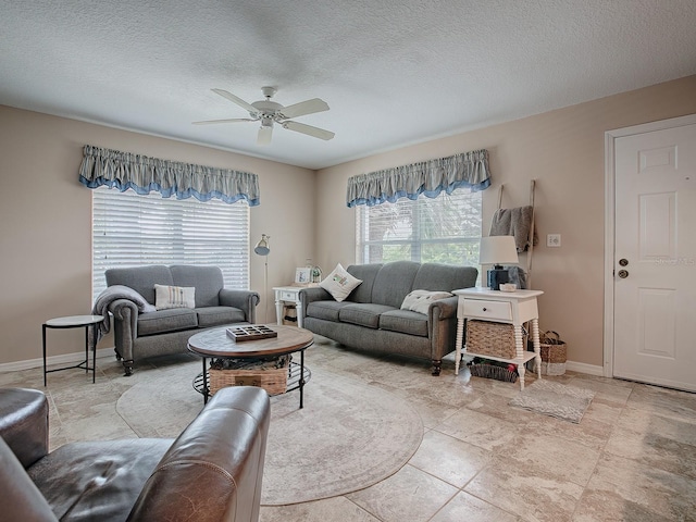 living room featuring ceiling fan, a textured ceiling, and light tile patterned floors