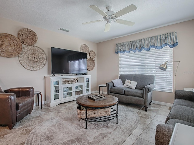 tiled living room with ceiling fan and a textured ceiling