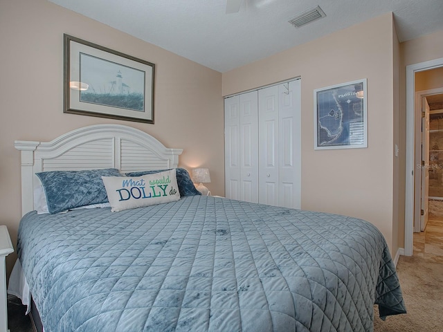 carpeted bedroom with ceiling fan and a closet