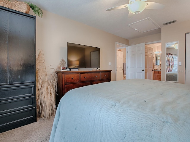 carpeted bedroom with ensuite bath and ceiling fan