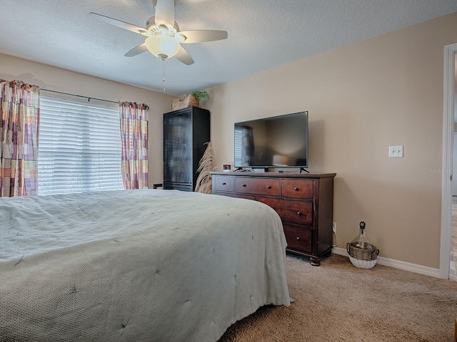 bedroom with light carpet, ceiling fan, and a textured ceiling