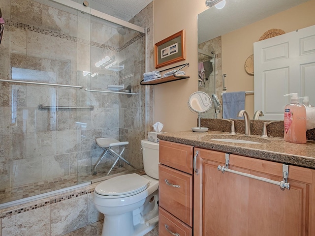 bathroom with toilet, a shower with door, and vanity