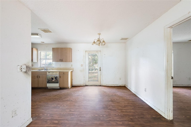 kitchen featuring pendant lighting, an inviting chandelier, white dishwasher, dark wood-type flooring, and a textured ceiling