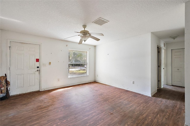 unfurnished living room with ceiling fan, dark wood-type flooring, and a textured ceiling