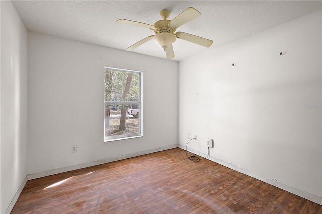 empty room featuring ceiling fan, wood-type flooring, and a textured ceiling