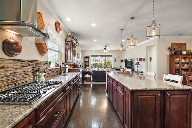 kitchen featuring sink, a kitchen island, island exhaust hood, and stainless steel gas cooktop