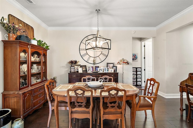 dining room with dark wood-type flooring, crown molding, and an inviting chandelier