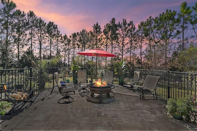 patio terrace at dusk featuring an outdoor fire pit