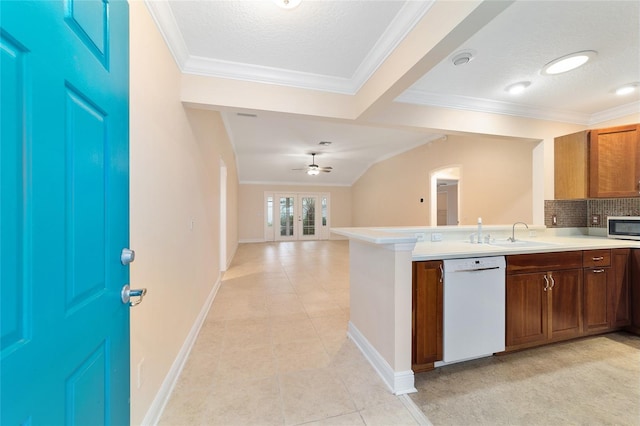 kitchen with sink, white dishwasher, tasteful backsplash, a textured ceiling, and kitchen peninsula