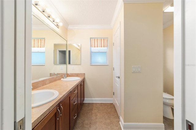 bathroom with ornamental molding, vanity, and toilet