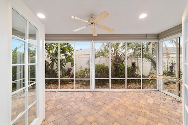 unfurnished sunroom with ceiling fan