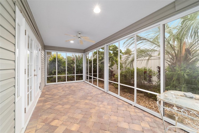 unfurnished sunroom featuring ceiling fan