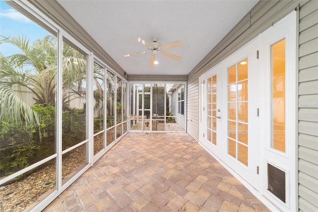 unfurnished sunroom featuring ceiling fan