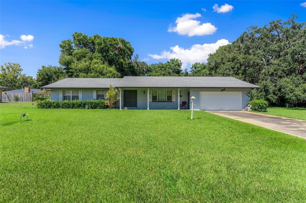 ranch-style house featuring a garage and a front lawn