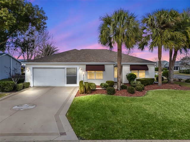 ranch-style home featuring a garage and a lawn